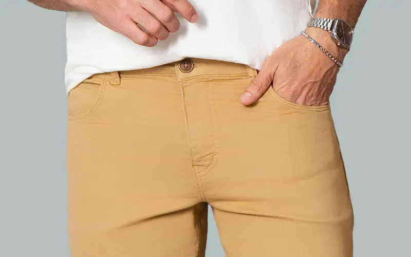 Detalhe do cós, botão e bolso de uma calça